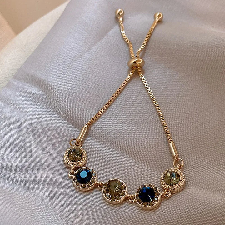 Gold-tone round-stone bracelet with green and blue bezel settings