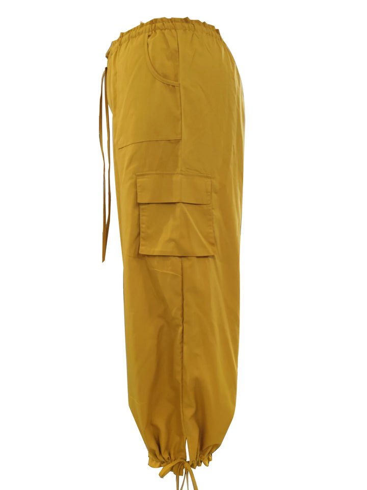 Side view of ginger yellow cargo pants with a flap pocket and drawstring waist and cuff