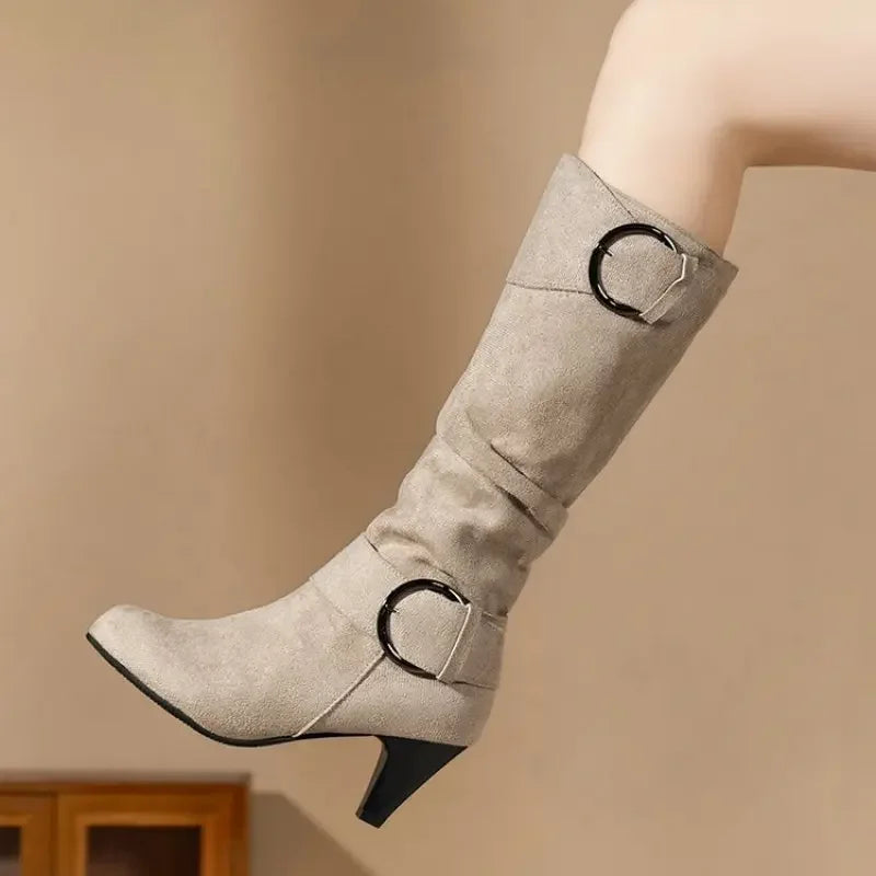 Gray knee-high boot with decorative buckles on a beige background