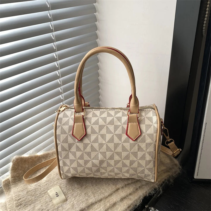 White PU handbag with geometric triangle print, zip-top, top handles, and adjustable strap