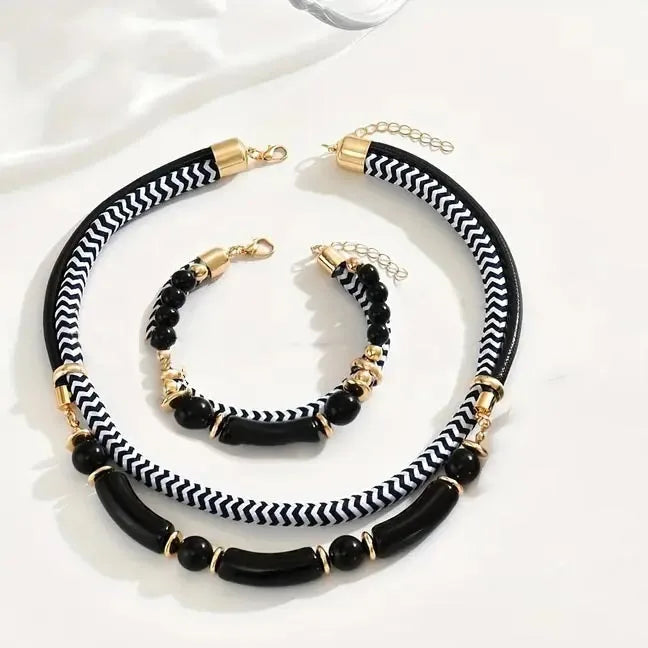 Black and white striped necklace with gold accents on a white background