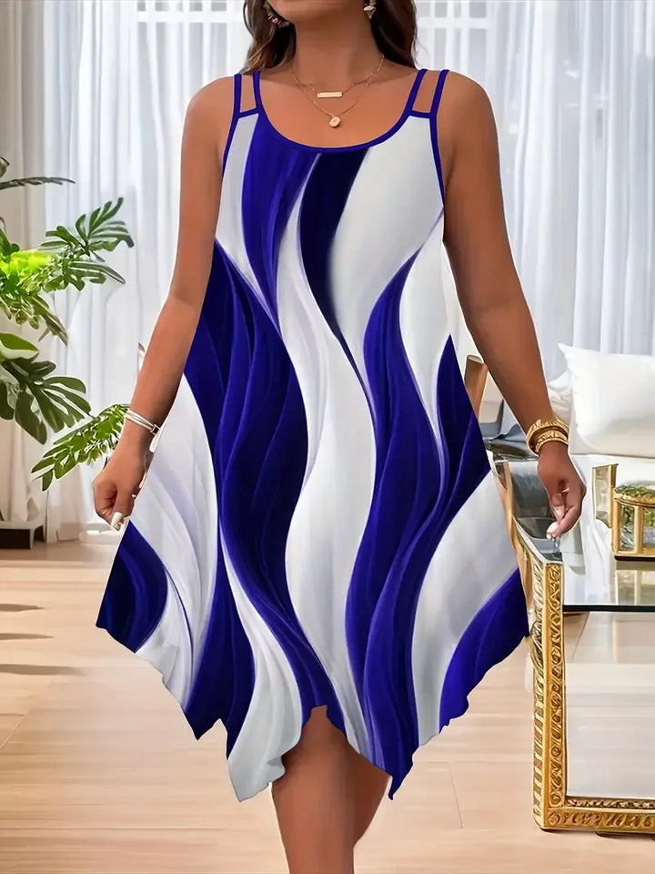 Woman wearing a blue and white dress with a wavy pattern in a room with a plant and furniture.