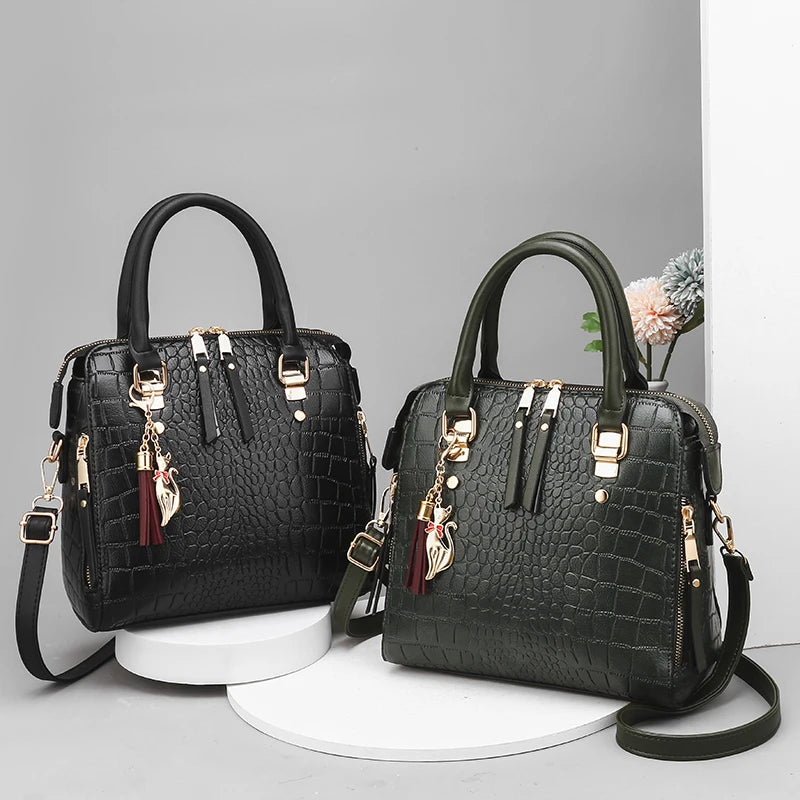 Pair of crocodile-embossed tote bags, black and dark green, with gold hardware and straps