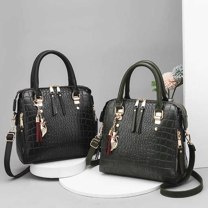 Pair of crocodile-embossed tote bags, black and dark green, with gold hardware and straps