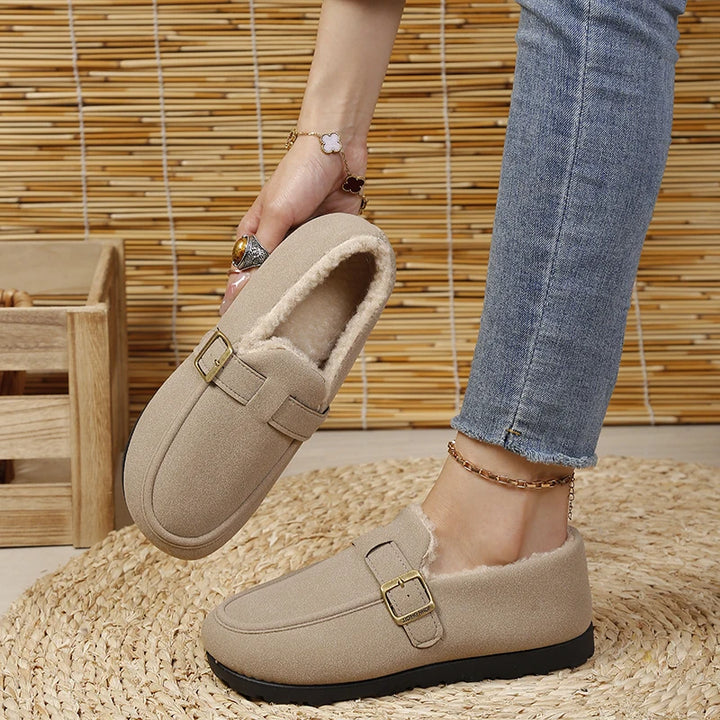 Beige slip-on loafer with gold buckle, worn with jeans, short plush lining