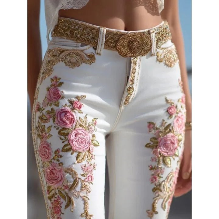 White high-waist straight-leg jeans with pink rose embroidery and ornate gold belt detail
