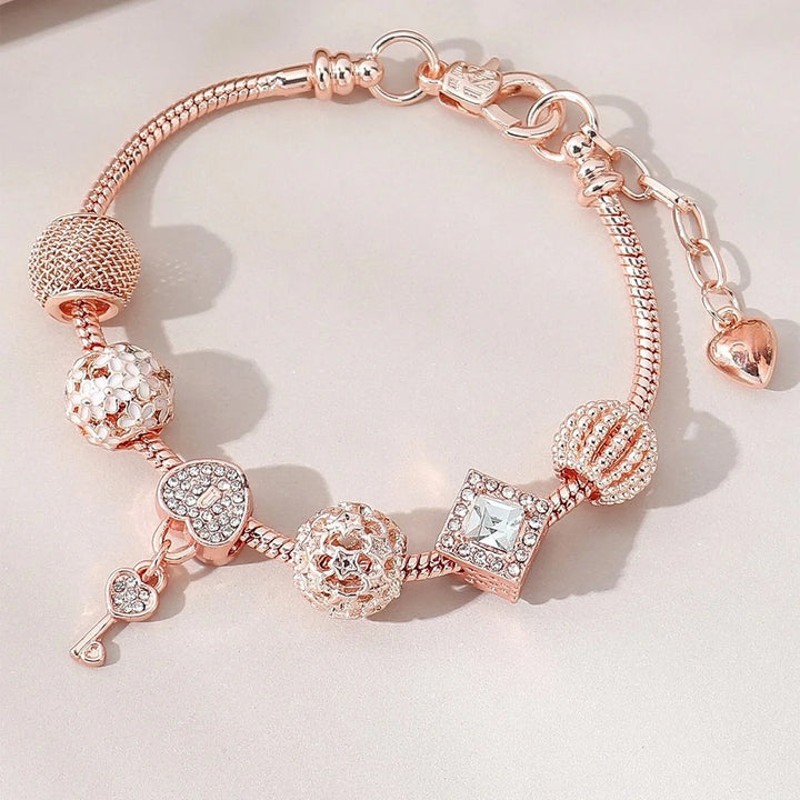 Rose gold charm bracelet with rose, heart, and sparkling crystal square bead charms