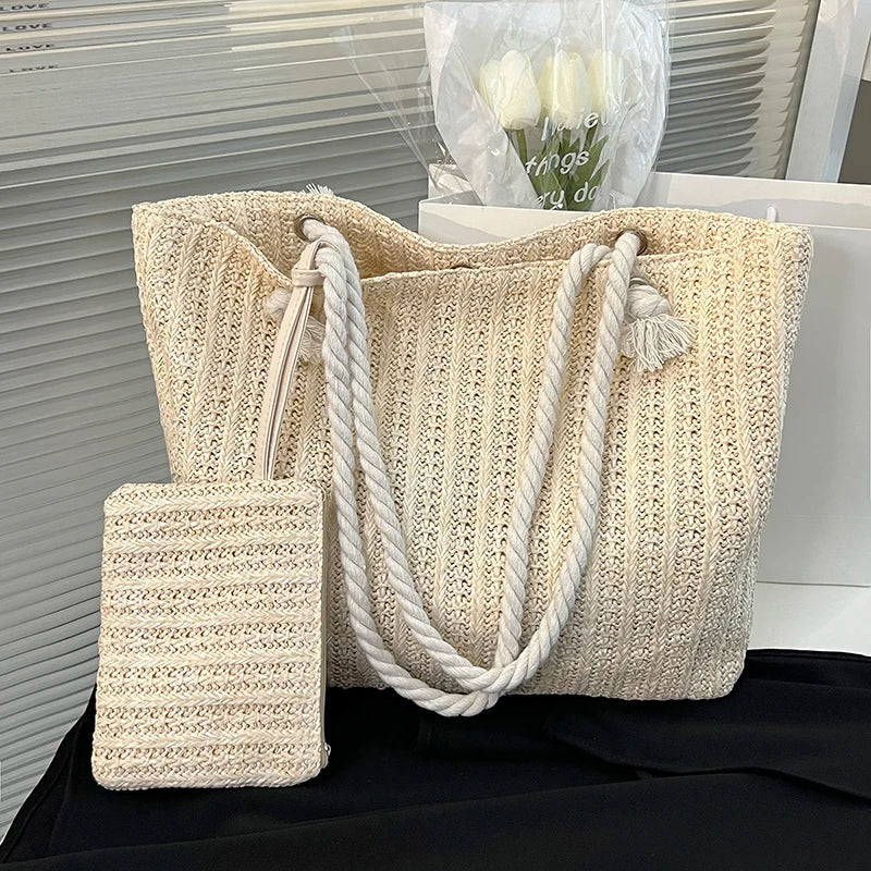 Beige woven tote bag with rope handle on a black surface