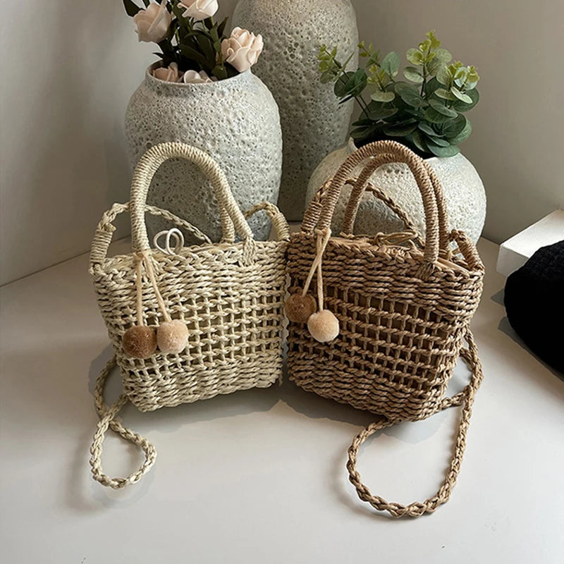 Two-tone knit straw bucket bags with pom-pom charms and braided crossbody straps
