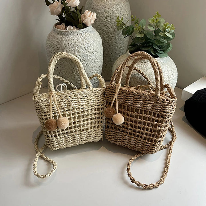 Two-tone knit straw bucket bags with pom-pom charms and braided crossbody straps