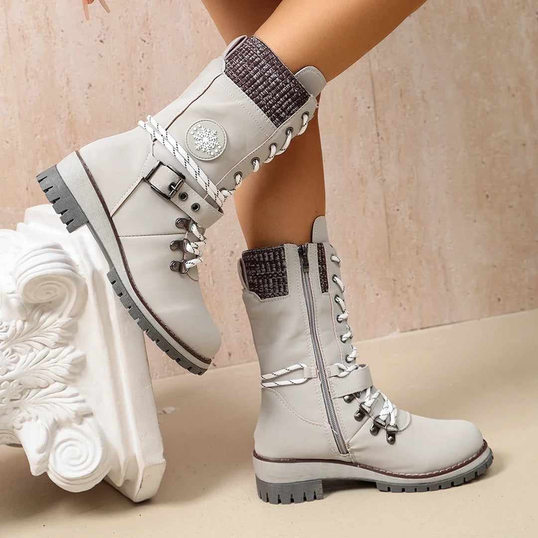 Women’s white winter boots with lace-up front, side strap detail, and grippy tread sole.
