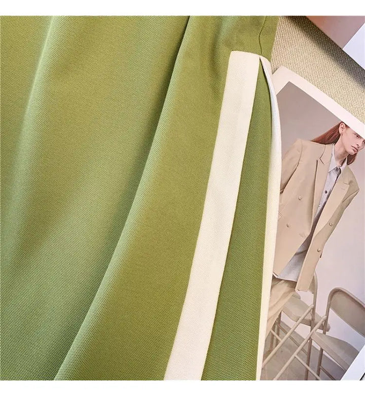 Green polo dress fabric detail with white side panel trim at the seam