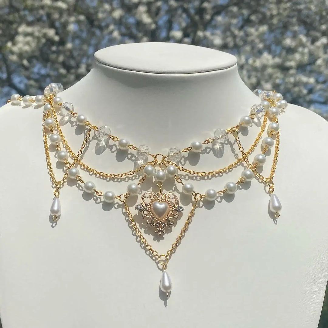 Ivory pearl and gold-tone multi-strand necklace on bust with heart pendant and dangles
