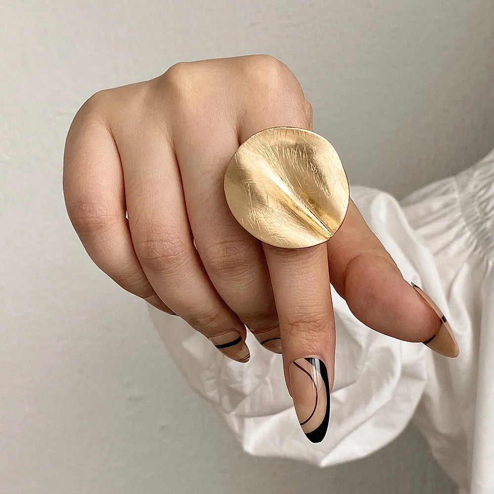 Gold tone oval mood ring with sculpted band and glossy textured surface