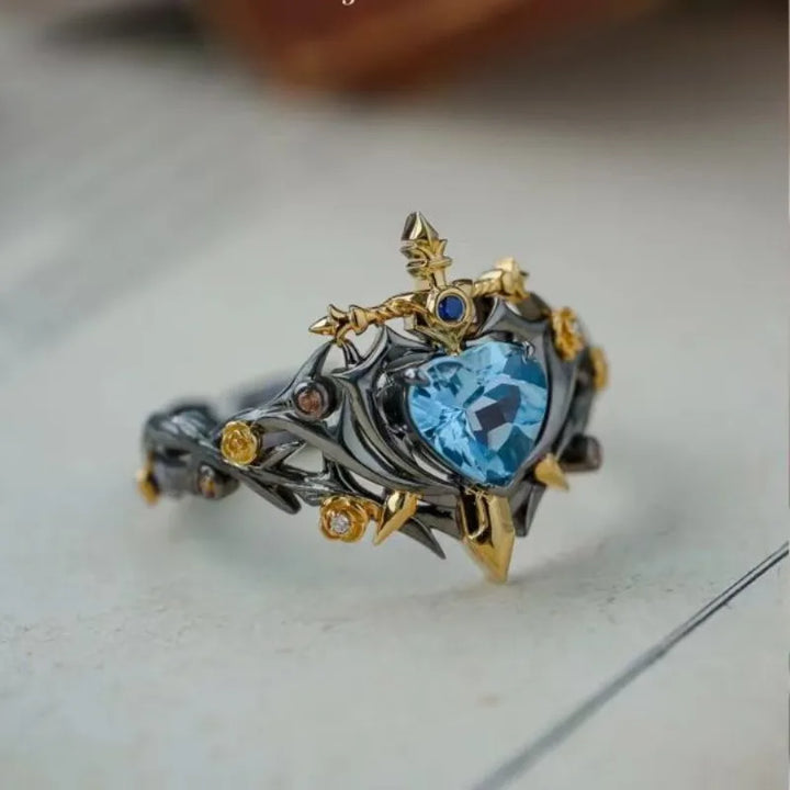 Heart blue zircon with small blue center gem, thorn prongs and gold filigree ring