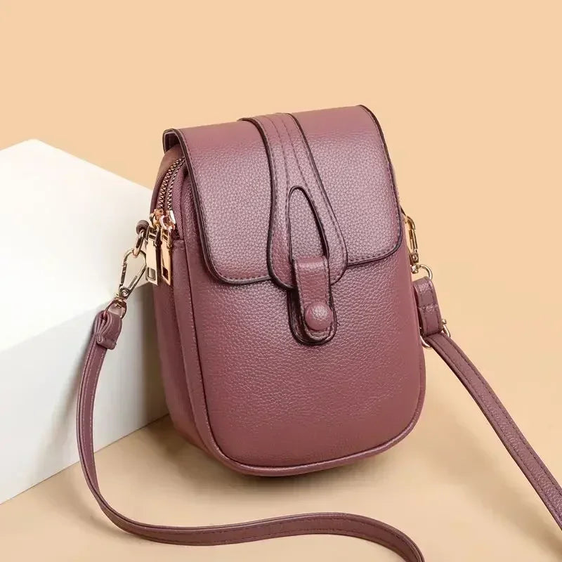 Small crossbody handbag in purple with flap front and adjustable shoulder strap