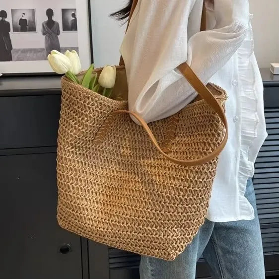Person holding a woven bag with white tulips indoors