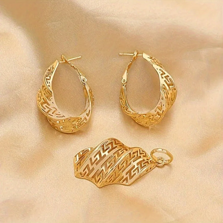 Gold hoop earrings and a matching pendant on a beige fabric background