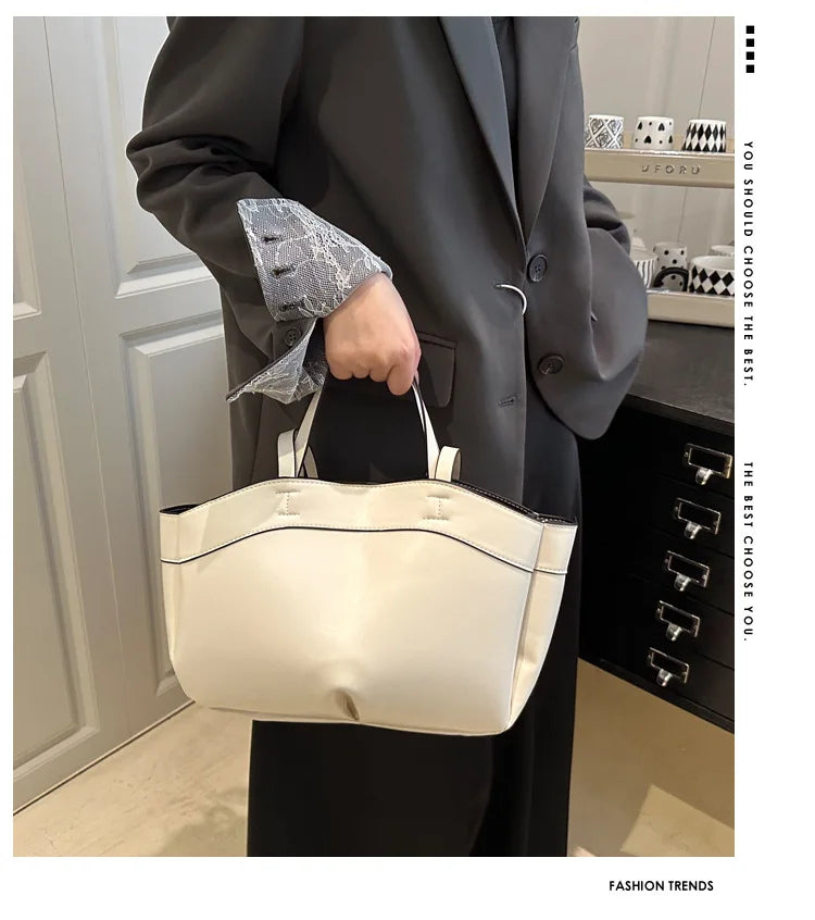 Person holding a white handbag in an indoor setting