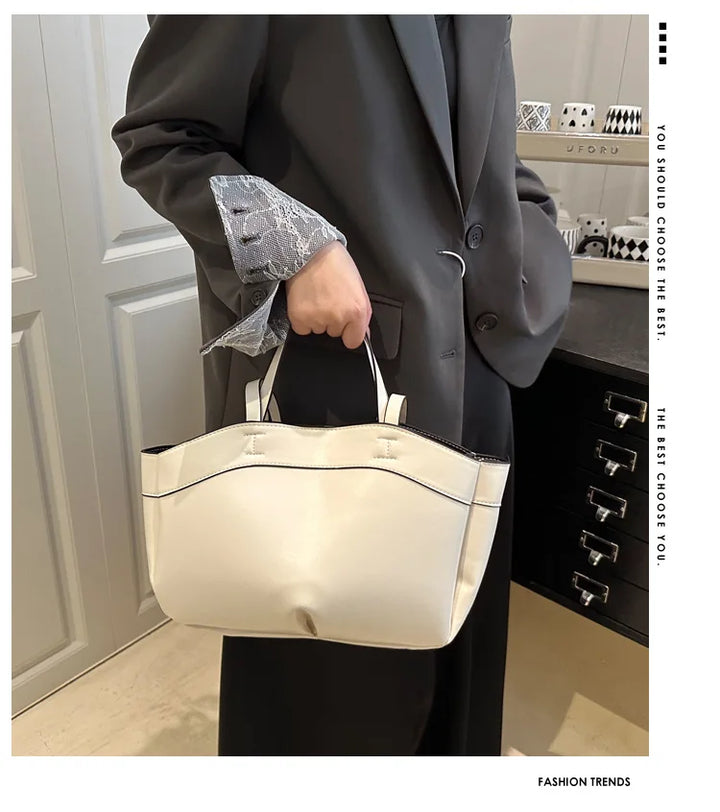 Person holding a white handbag in an indoor setting