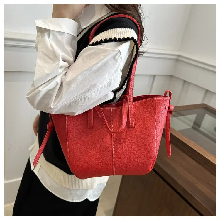 Person holding a red handbag indoors