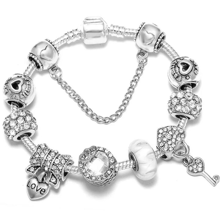 Silver bracelet with clear crystal heart beads, love tag, and key pendant charm