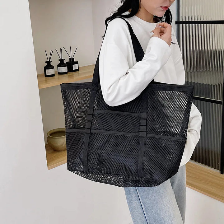 Black sheer mesh tote bag with open top and interior zip pocket, wide carry handles