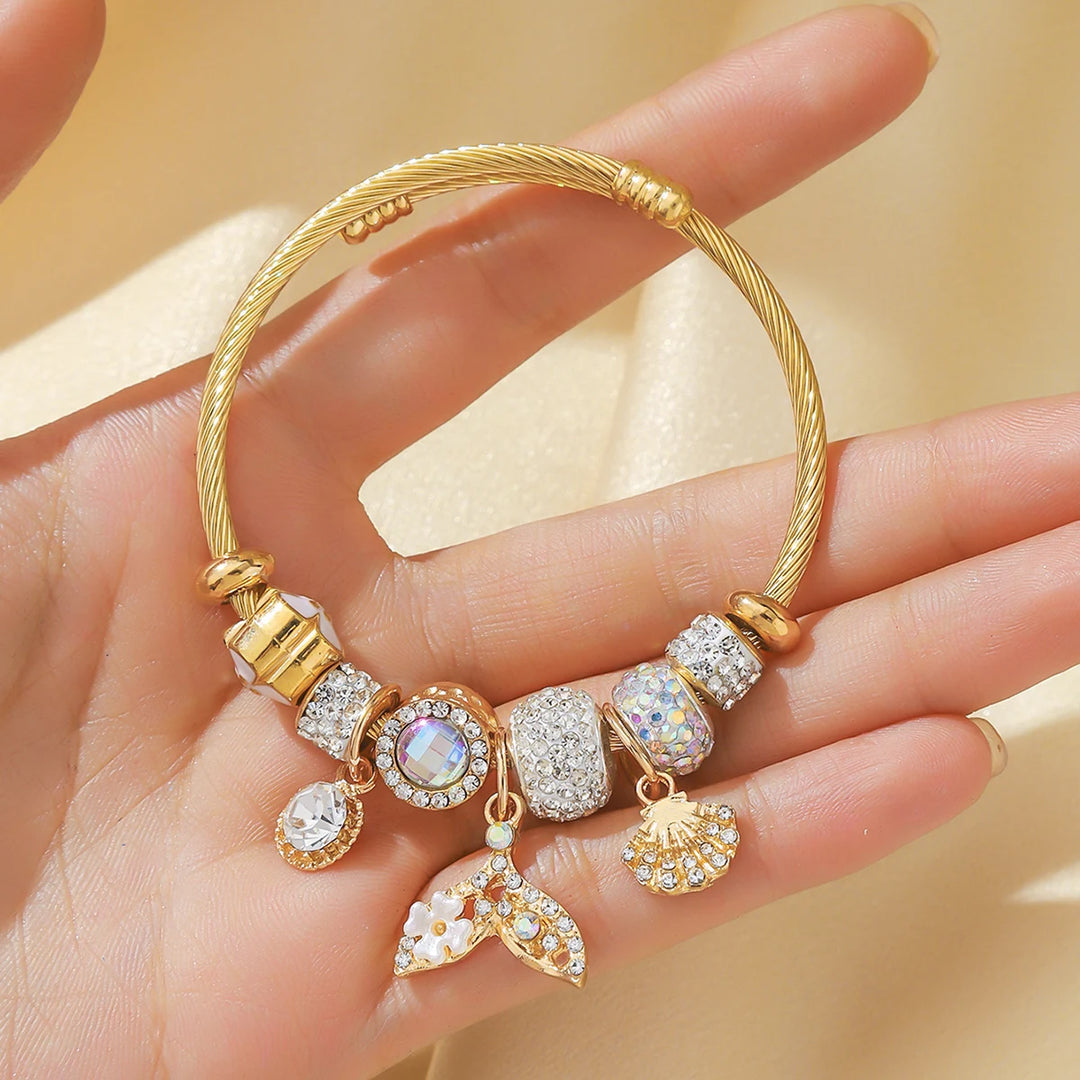 Goldfarbener Armreif mit Strassperlen und bunten Charms, mehrere kleine Anhänger