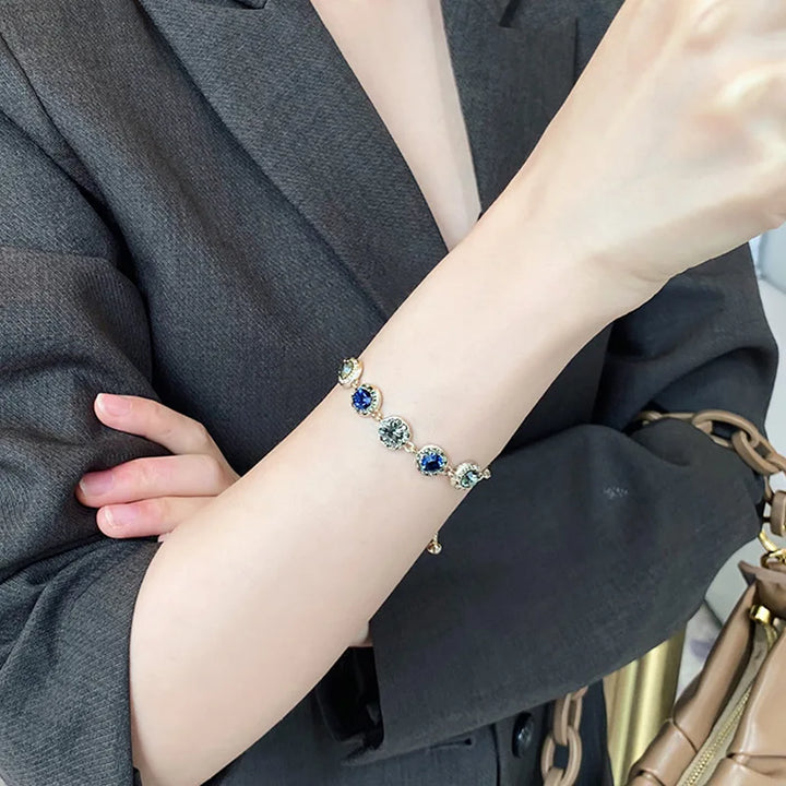 Gold-tone tennis bracelet with round blue and green stones
