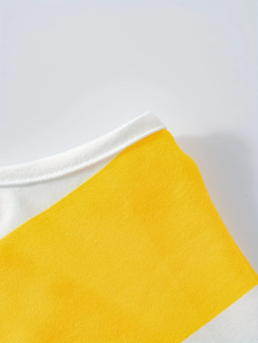 Close-up of a yellow fabric swatch on a white background