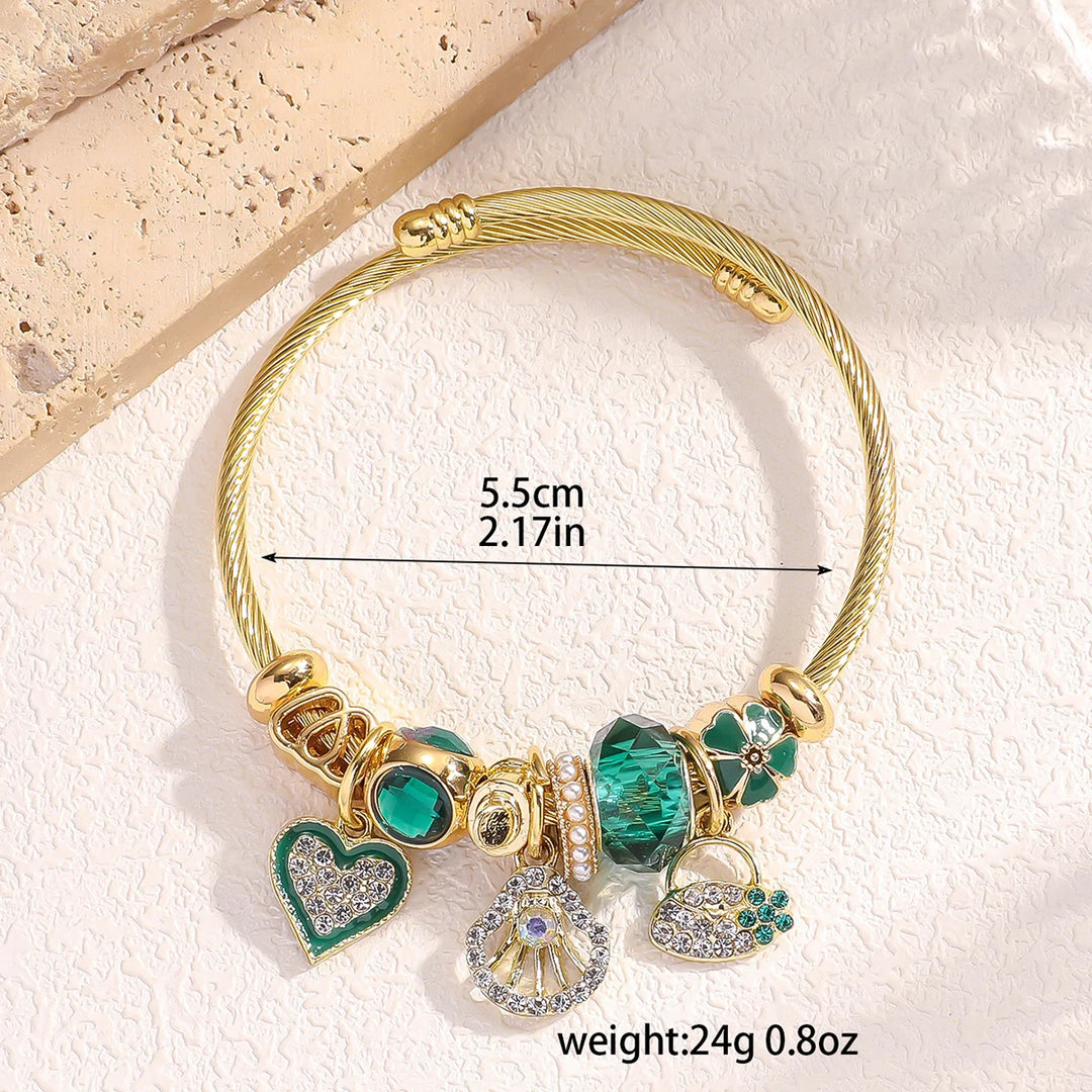 Armreif Ø58–60mm mit grünen Steinen, Herz- und Anhänger-Charms, goldfarben
