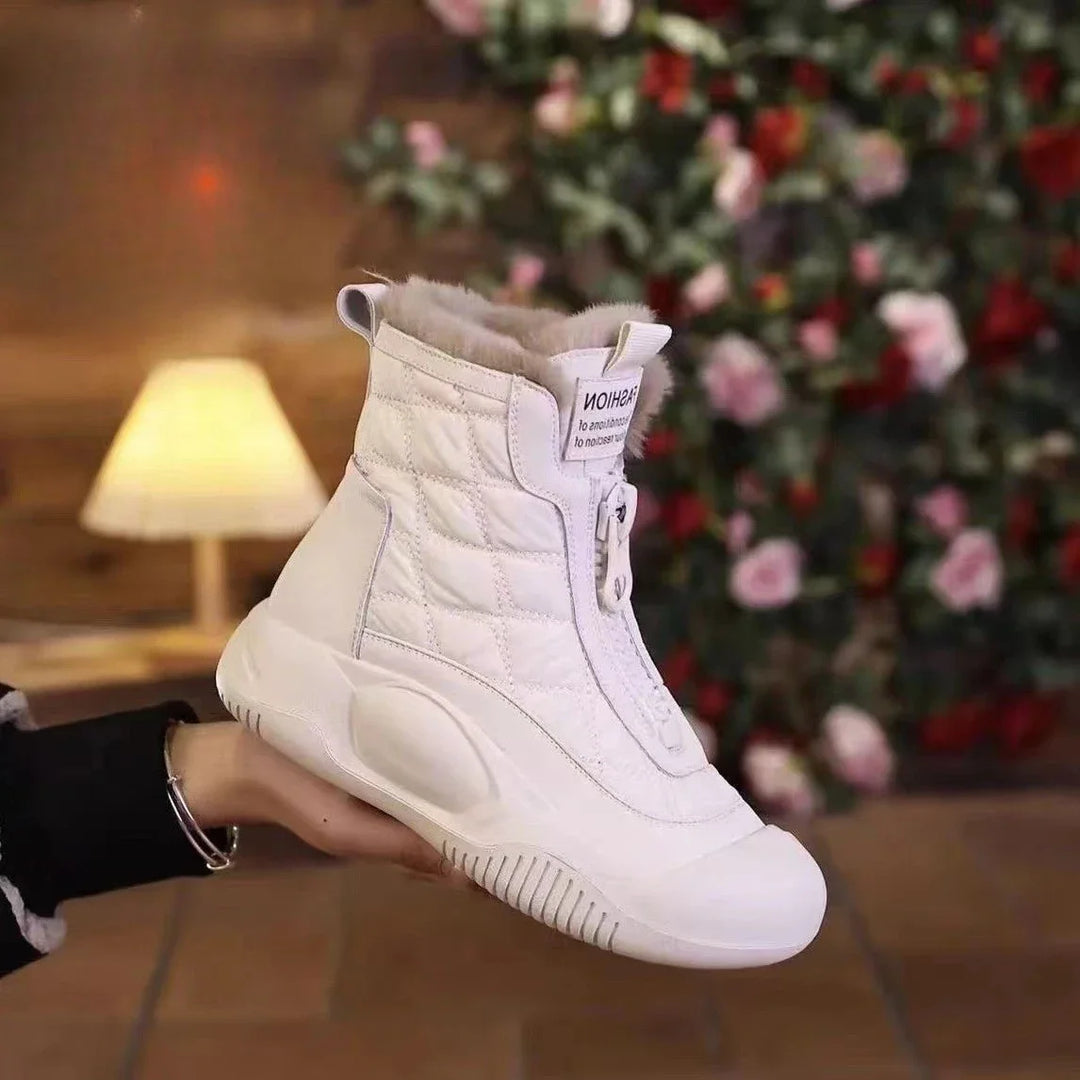 White high-top sneaker held by a person with a blurred Christmas tree in the background