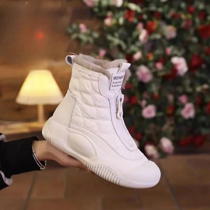 White high-top sneaker held by a person with a blurred Christmas tree in the background