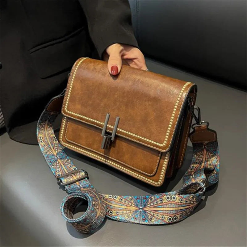 Mini crossbody bag in tan with flap lock, decorative beaded trim, and patterned strap