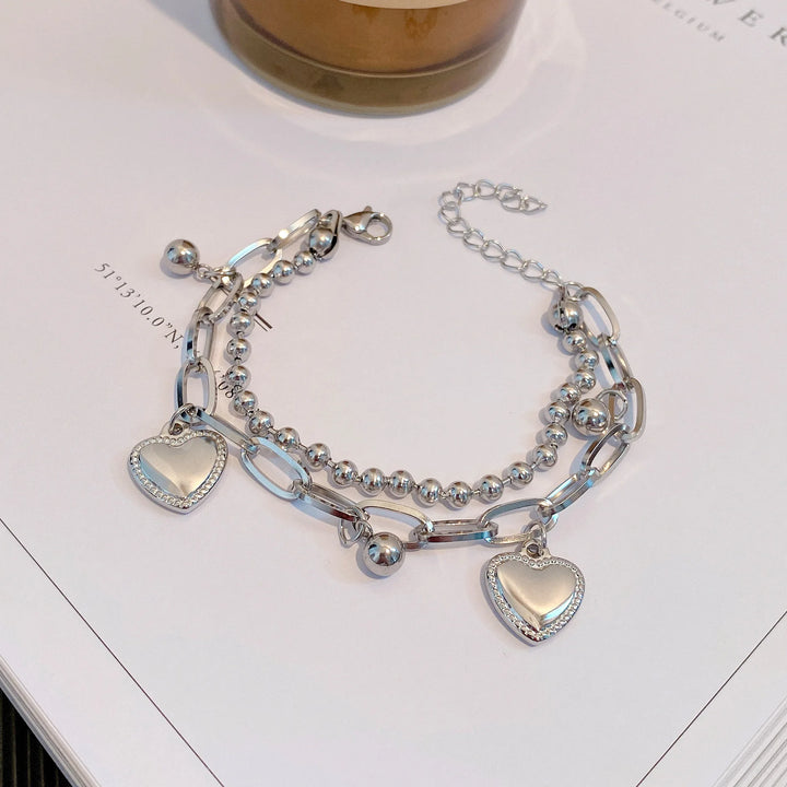 Silver bracelet with heart charms in a box, brand name visible