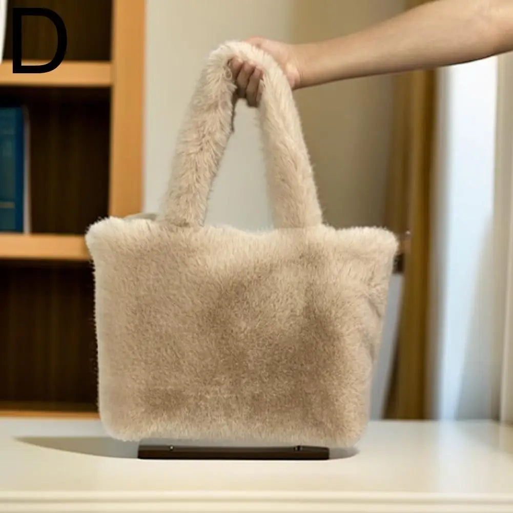 Beige fluffy handbag held by a person with a blurred indoor background