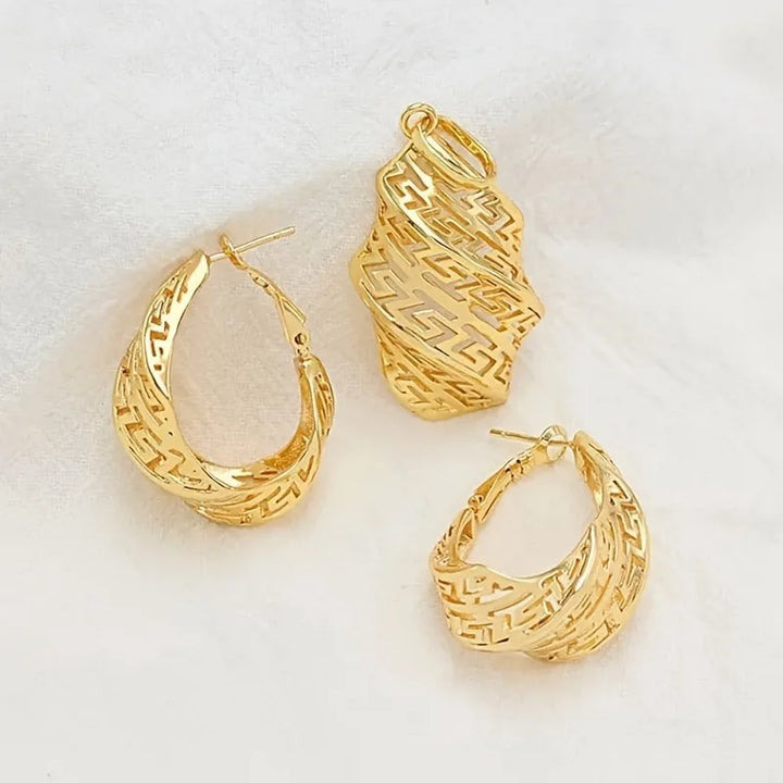 Gold hoop earrings and a matching pendant on a beige fabric background
