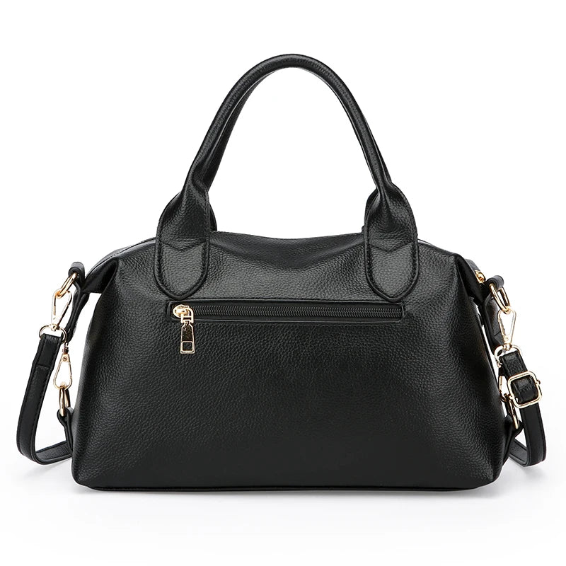Black soft leather tote bag with short handles, front zip pocket, and crossbody strap