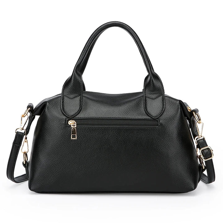 Black soft leather tote bag with short handles, front zip pocket, and crossbody strap