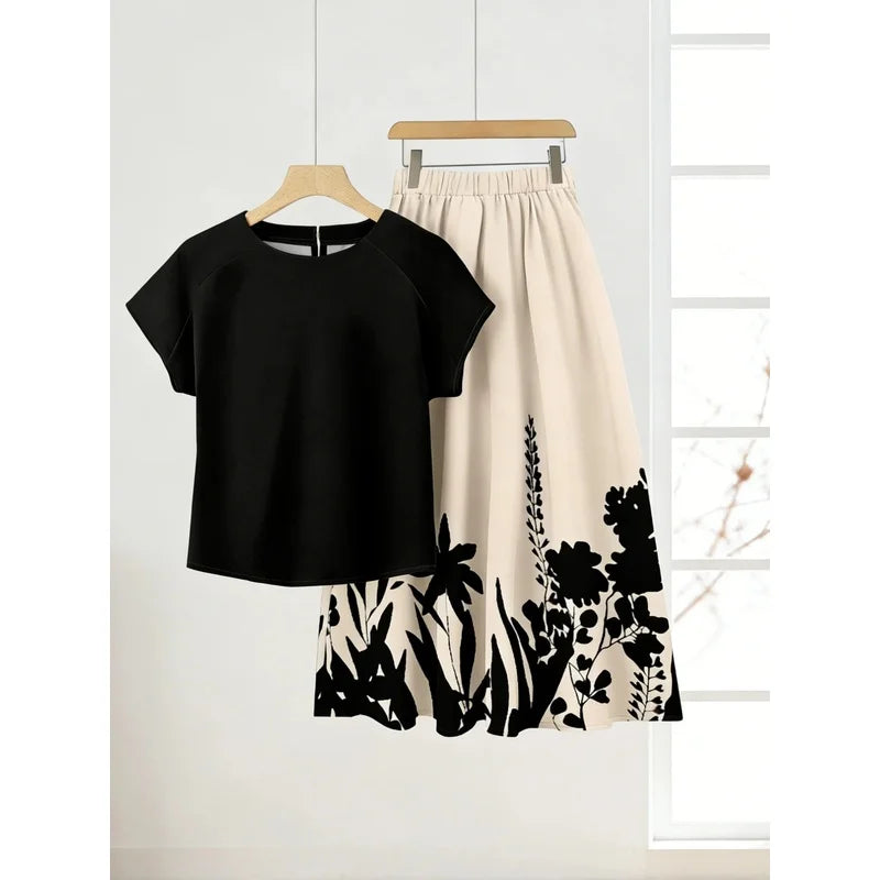 Black short-sleeve top and full cream skirt with black floral and plant silhouettes