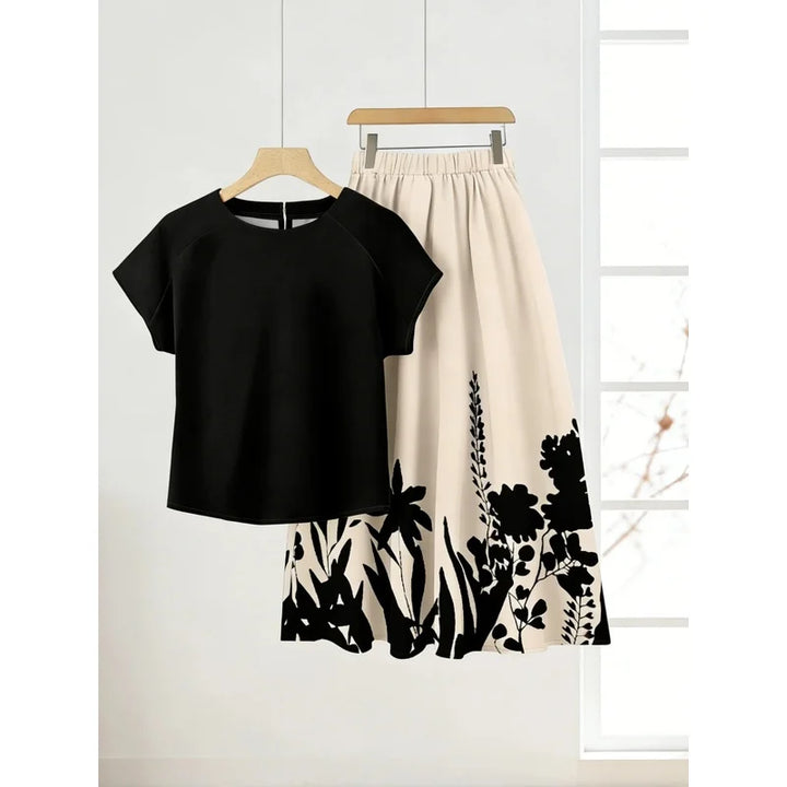Black short-sleeve top and full cream skirt with black floral and plant silhouettes
