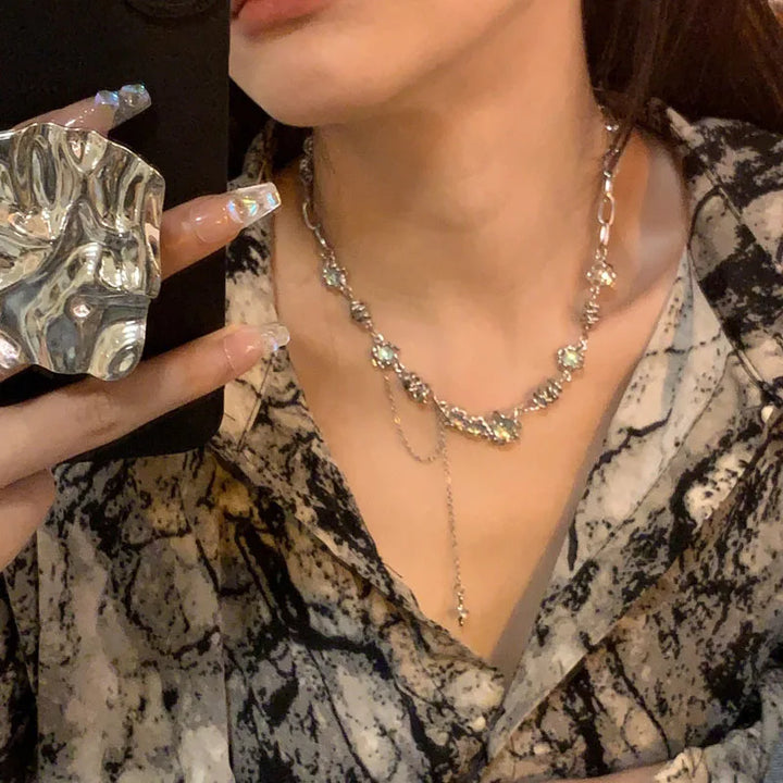 Close-up of a person wearing a silver necklace with a patterned top.