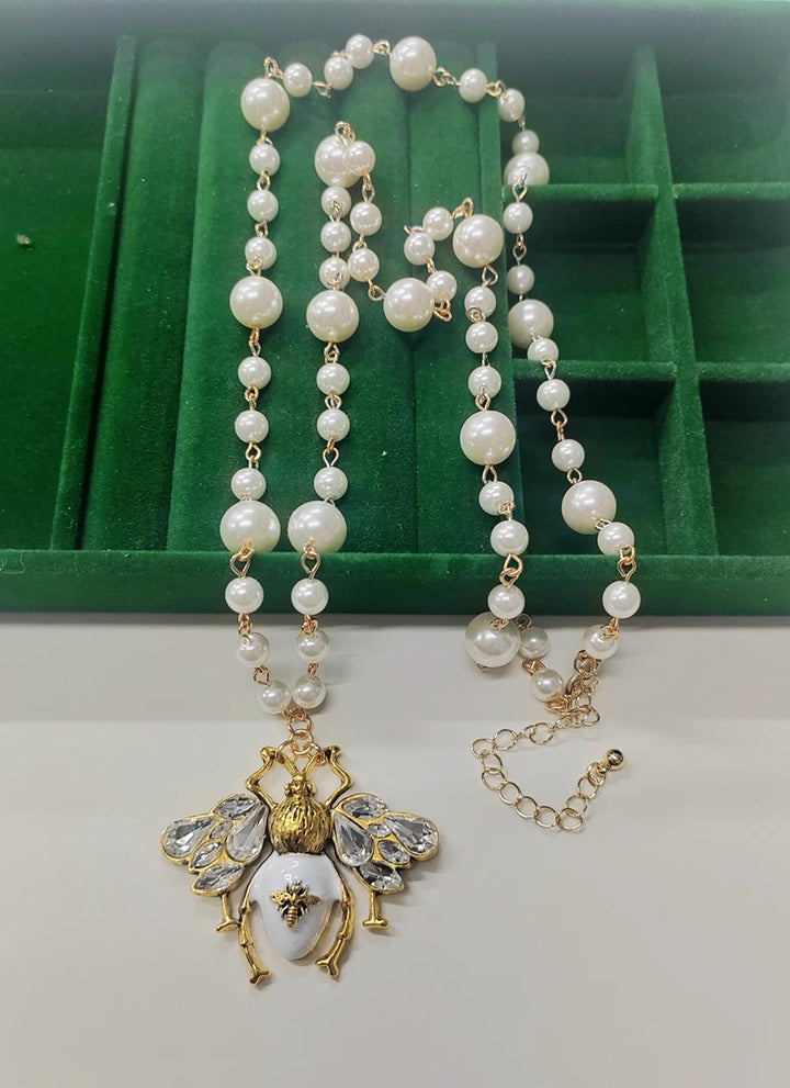 Pearl necklace with a decorative pendant on a green and white background