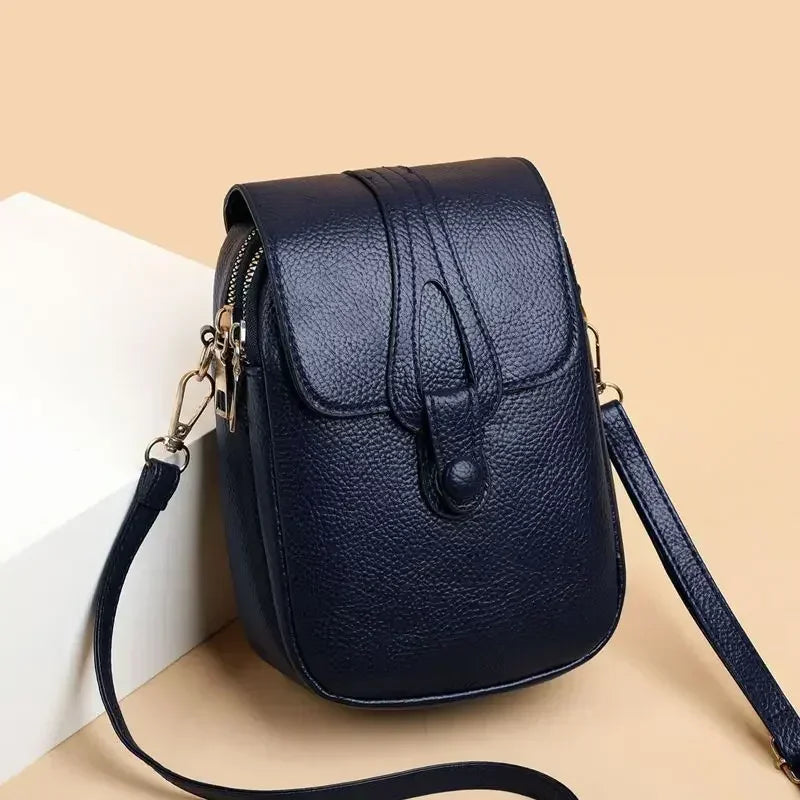 Small crossbody handbag in dark blue with flap front and adjustable shoulder strap