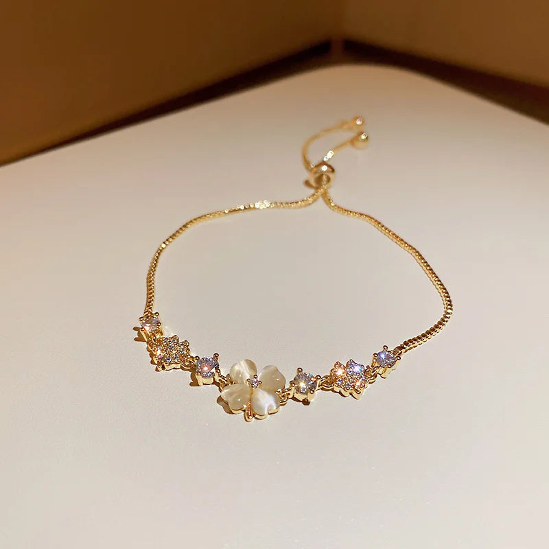 Gold-tone bracelet with mixed bead links and flower and oval stone charms