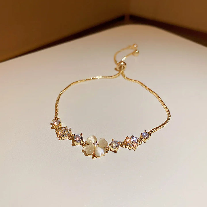 Gold-tone bracelet with mixed bead links and flower and oval stone charms