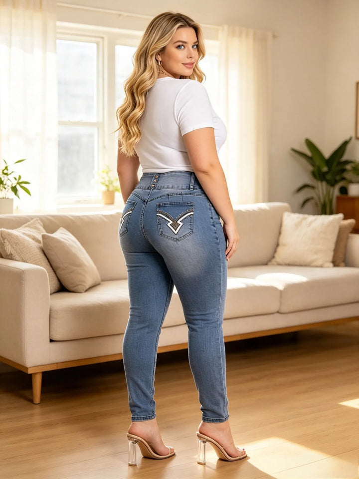 High-rise blue denim jeans with rhinestone back pocket embroidery and slim tapered fit