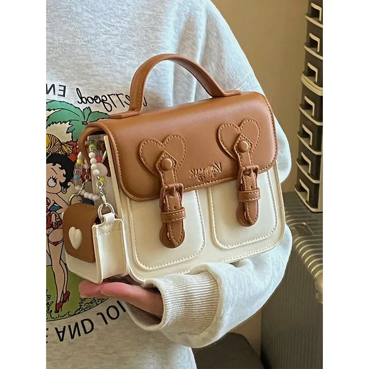 Two-tone women’s shoulder handbag with heart front flap and tassel charm keyring