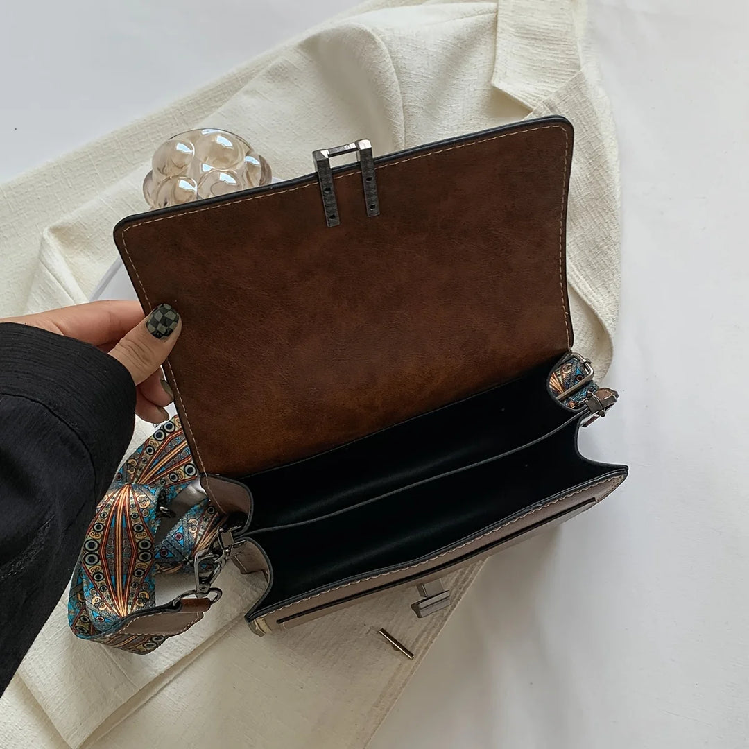 Mini crossbody bag in brown with hinged flap and strap attachment, open view