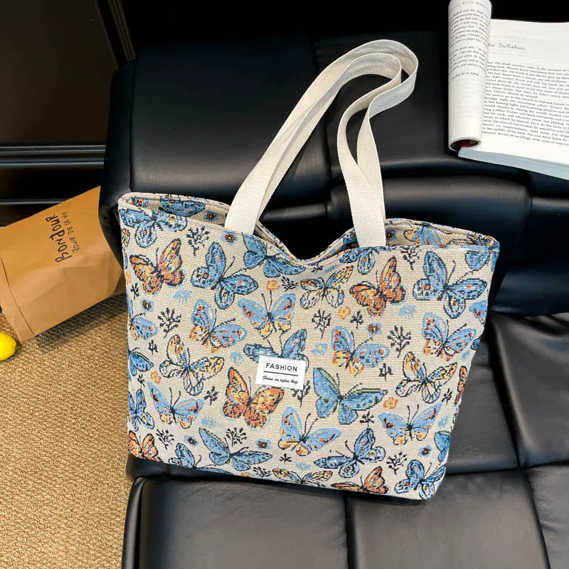 Boho floral canvas tote with butterfly print and light beige handles, front label panel